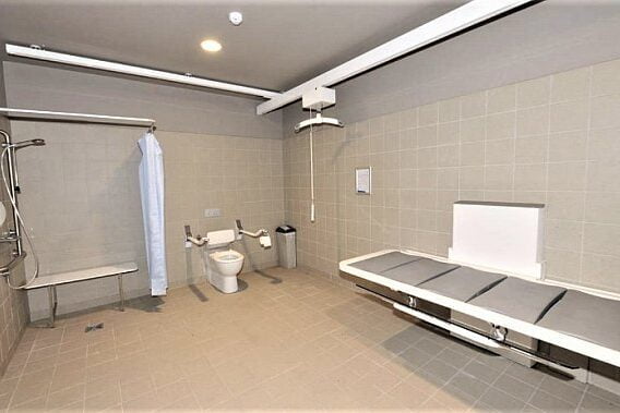 internal layout of disabled persons changing place with changing bench, toilet and washing facilities